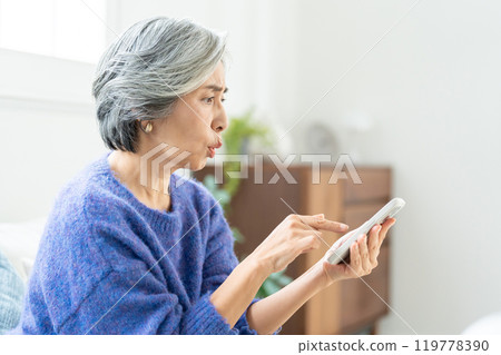 操作智能手機的資深婦女 119778390