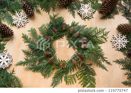 Preparation for Christmas holiday. Christmas composition of wreath, decor, twigs and snowflakes. Woman prepare a wreath. Top view and copy space. Flat lay. Preparation for Christmas holiday. Christmas composition of wreath, decor, twigs and snowflakes. Woman prepare a wreath. Top view and copy space. Flat lay. 119778747
