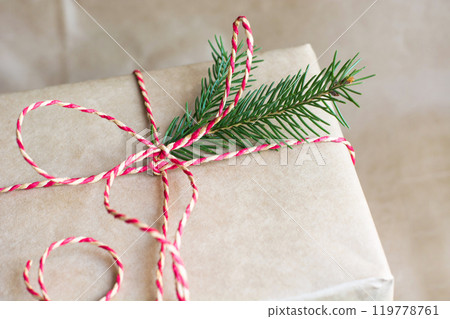 Christmas or new year gift box with red ribbon from craft paper. Close up. Christmas or new year gift box with red ribbon from craft paper. Close up. 119778761