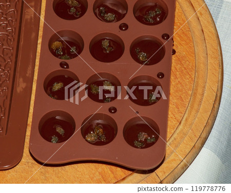 Silicone molds for shaping chocolate and sweets are filled with hot chocolate to cool. Silicone molds for shaping chocolate and sweets are filled with hot chocolate to cool. 119778776