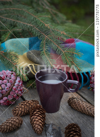 Season cup of hot tea on wooden table. Still life of cones and fir branches. Preparing for Christmas. Warming beverage. Season cup of hot tea on wooden table. Still life of cones and fir branches. Preparing for Christmas. Warming beverage. 119778778