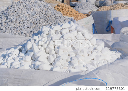 White marble pebbles are sold in construction market. Close up of materials pile. Materials for decoration and construction. White marble pebbles are sold in construction market. Close up of materials pile. Materials for decoration and construction. 119778801