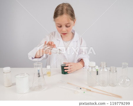 Caucasian girl doing chemical experiments on a white background. Caucasian girl doing chemical experiments on a white background. 119779299