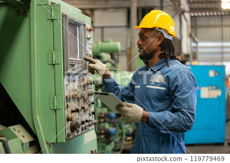 Male african american workers wear yellow hard hat holding wrench working on repairing factory machinery. man maintenance Factory, mechanical repairman concept. Male african american workers wear yellow hard hat holding wrench working on repairing factory machinery. man maintenance Factory, mechanical repairman concept. 119779469