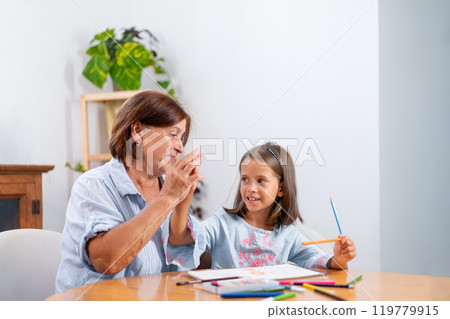 Grandmother giving high five to girl holding 119779915