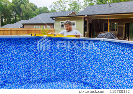 In back yard of house, assembly of construction ground swimming pool is underway 119780322
