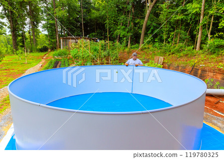 Worker is currently installing metal frame of an above ground pool 119780325