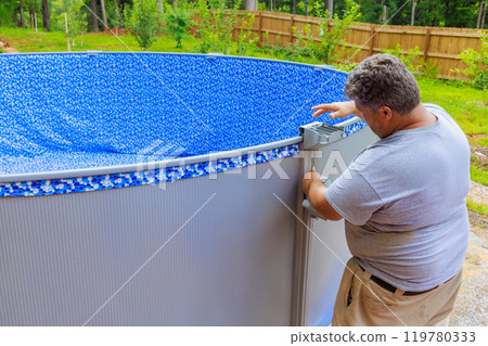 Assembling construction ground pool in back yard of house in order to take advantage to relax 119780333