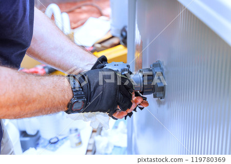 An installation technician installs water filtration system, chlorination system in pool frame An installation technician installs water filtration system, chlorination system in pool frame 119780369
