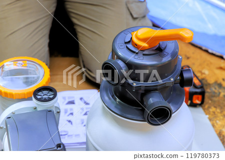 Swimming pool maintenance worker assemble sand filter system tank well as pool cleaning equipment Swimming pool maintenance worker assemble sand filter system tank well as pool cleaning equipment 119780373