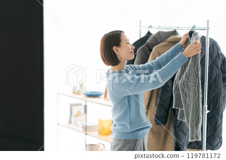 女人把衣服掛在衣架上 119781172