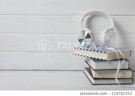 Books with modern headphones, on a light background. 119782352