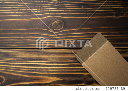 Top view of brown envelope and postcard on wooden background 119783489