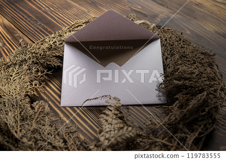 Envelope and postcard with brown card with words Congratulations on it with wreath 119783555