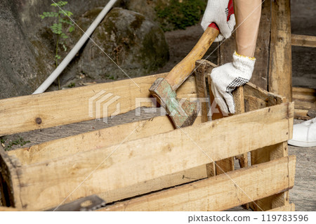 Workers in safety vest and glove using axe to work disassembling pallet parts Workers in safety vest and glove using axe to work disassembling pallet parts 119783596