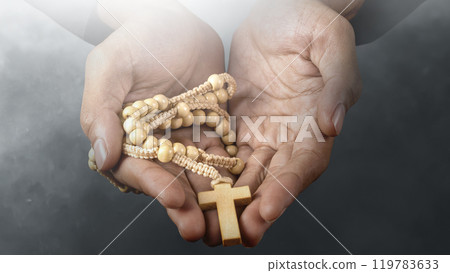 Man holding a rosary beads with dark sky background. Symbol of faith and worship in God. People christianity prayer 119783633