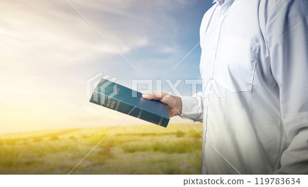 Man holding a holy bible in his hand. Symbol of faith and worship in God. People christianity prayer Man holding a holy bible in his hand. Symbol of faith and worship in God. People christianity prayer 119783634