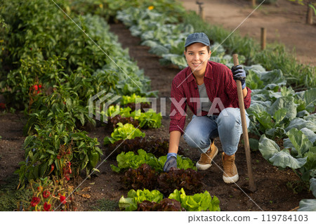 Woman with a hoe in the garden 119784103