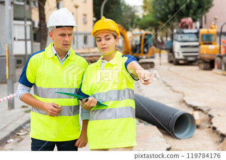 Two qualified engineers are discussing a construction plan 119784176