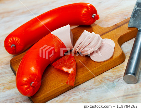 Mortadela sausage cut in slices on a wooden surface 119784262