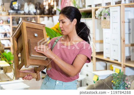 Portrait of woman choosing dressing table in furniture store 119784288