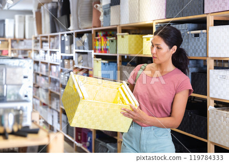 Asian Woman buying wicker fabric box at hardware store 119784333