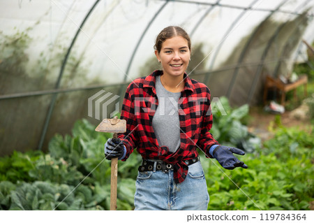 Farmer peasant woman works with garden plants in greenhouse Farmer peasant woman works with garden plants in greenhouse 119784364