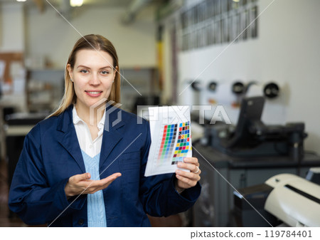 Portrait of positive woman printing office worker with colour test page 119784401