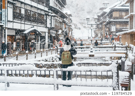 Woman tourist Visiting Ginzan Onsen in Yamagata, happy Traveler sightseeing Japanese Onsen village with Snow in winter season. landmark and popular for attraction in Japan. Travel and Vacation concept Woman tourist Visiting Ginzan Onsen in Yamagata, happy Traveler sightseeing Japanese Onsen village with Snow in winter season. landmark and popular for attraction in Japan. Travel and Vacation concept 119784529