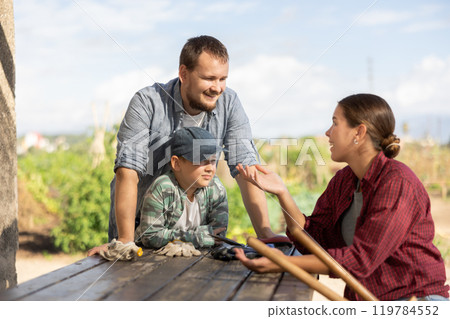 Man woman and boy talking while harvesting 119784552