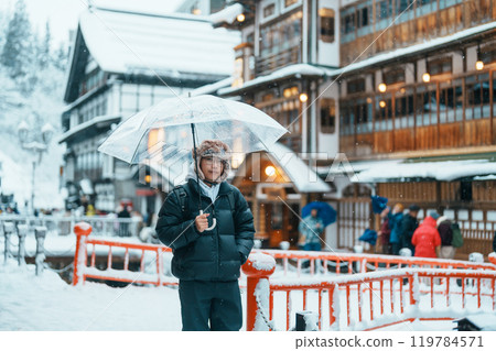 man tourist Visiting Ginzan Onsen in Yamagata, happy Traveler sightseeing Japanese Onsen village with Snow in winter season. landmark and popular for attraction in Japan. Travel and Vacation concept man tourist Visiting Ginzan Onsen in Yamagata, happy Traveler sightseeing Japanese Onsen village with Snow in winter season. landmark and popular for attraction in Japan. Travel and Vacation concept 119784571