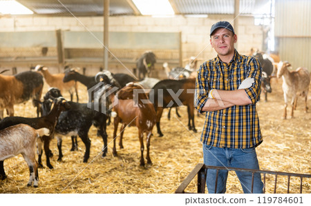Experienced livestock farm worker standing in goat stall Experienced livestock farm worker standing in goat stall 119784601