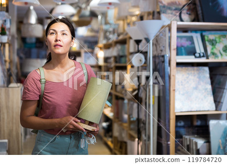 Asian woman choosing table lamp at store 119784720