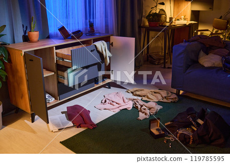 Wooden opened dresser, clothes and mess on floor after break-in at late night 119785595