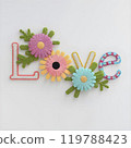 Embriodered floral letters LOVE. Crocheted summer wildflowers are gathered in an exquisite delicate bouquet. White background 119788423