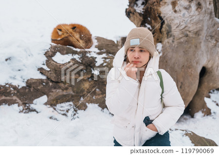 Woman tourist with Cute fox on snow in winter season at Zao fox village, traveler sightseeing Miyagi prefecture. landmark and popular for attraction near Sendai, Tohoku, Japan. Travel and Vacation 119790069