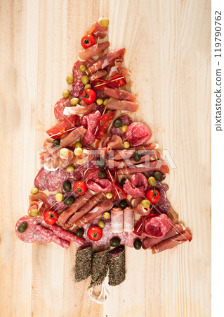 Christmas tree made of sausage on a background of a wooden wall 119790762
