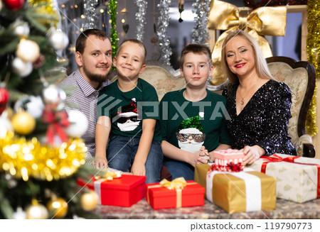 Family with mom and dad celebrates Christmas at home 119790773