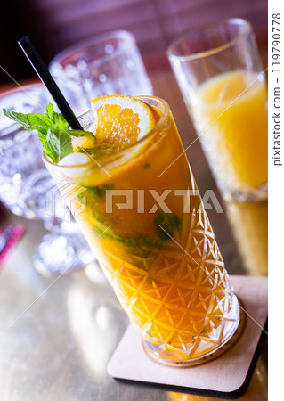 Non alcoholic sea buckthorn cocktail with mint and orange in a glass glass 119790778