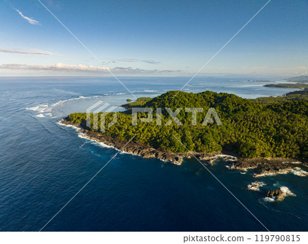 Beautiful ocean waves touching the tropical island. Blue sky and clouds. Travel concept. Surigao del Sur. Mindanao, Philippines. Beautiful ocean waves touching the tropical island. Blue sky and clouds. Travel concept. Surigao del Sur. Mindanao, Philippines. 119790815