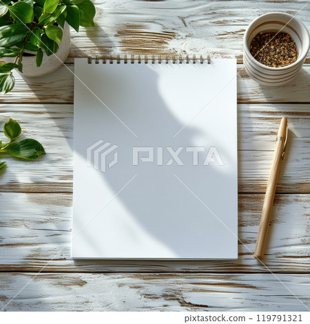 blank notepad on rustic wooden desk with pen and plant. sunlight casts gentle shadows, creating serene workspace atmosphere 119791321