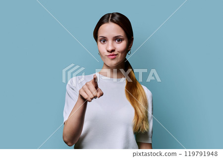 Young beautiful redhead teenage woman pointing finger you, on blue studio background. Youth, age college, advertising products goods services concept 119791948