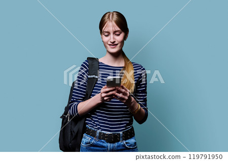 Young beautiful woman using smartphone on blue studio background Young beautiful woman using smartphone on blue studio background 119791950