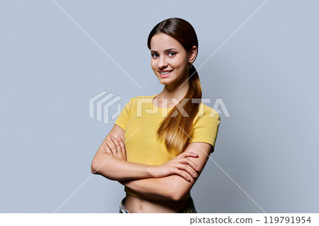 Portrait of beautiful red-haired girl with crossed arms on gray background Portrait of beautiful red-haired girl with crossed arms on gray background 119791954