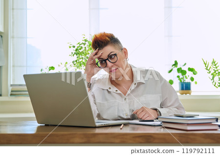 Portrait of mature woman working at home on computer laptop 119792111