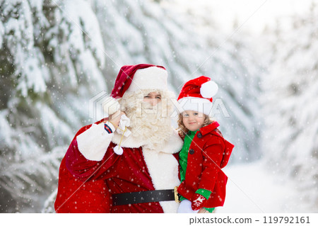 Kids and Santa with Christmas gifts in snow forest 119792161