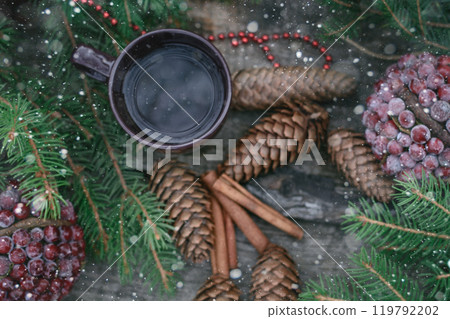 Season cup of hot tea on wooden table. Still life of cones and fir branches. Preparing for Christmas. Warming beverage. Season cup of hot tea on wooden table. Still life of cones and fir branches. Preparing for Christmas. Warming beverage. 119792202