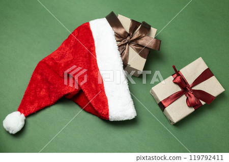 kraft gift boxes with burgundy and brown bows falling out of santa hat kraft gift boxes with burgundy and brown bows falling out of santa hat 119792411