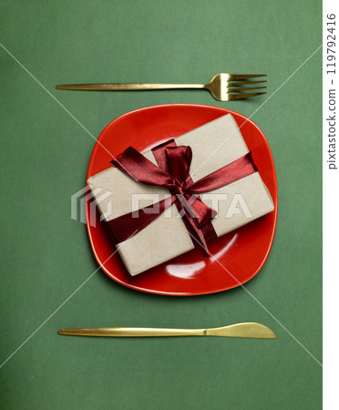 craft gift box on red plate with ribbon and cutlery 119792416