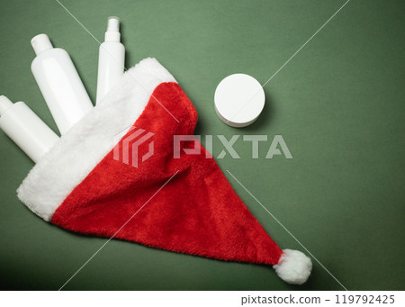 cosmetics fall out of Santa Claus hat on a green background 119792425